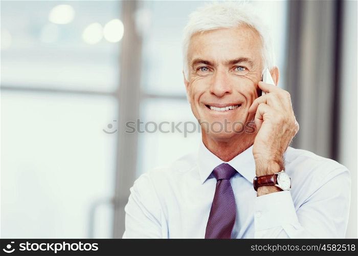 Businessman talking over phone in office. I am always in touch