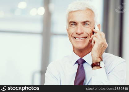 Businessman talking over phone in office. I am always in touch