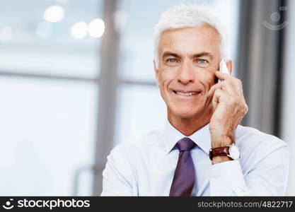 Businessman talking over phone in office. I am always in touch