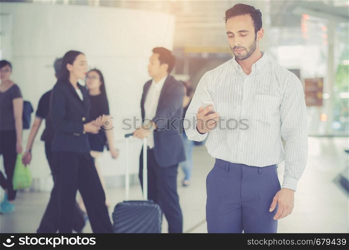 Businessman talking smart mobile phone with working team on background, man standing with confident, business teamwork concept.