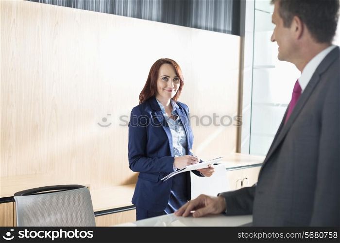 Businessman talking with receptionist in office