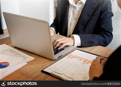 Businessman team working at office desk and using a digital computer laptop hands detail, computer and objects on the table