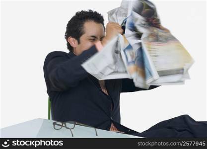 Businessman tearing a newspaper in frustration