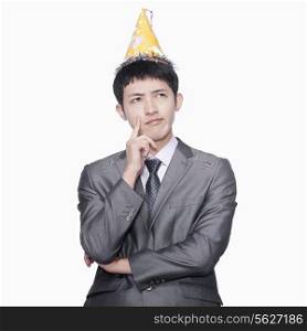 Businessman thinking, wearing party hat
