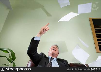 Businessman throwing paper in the air