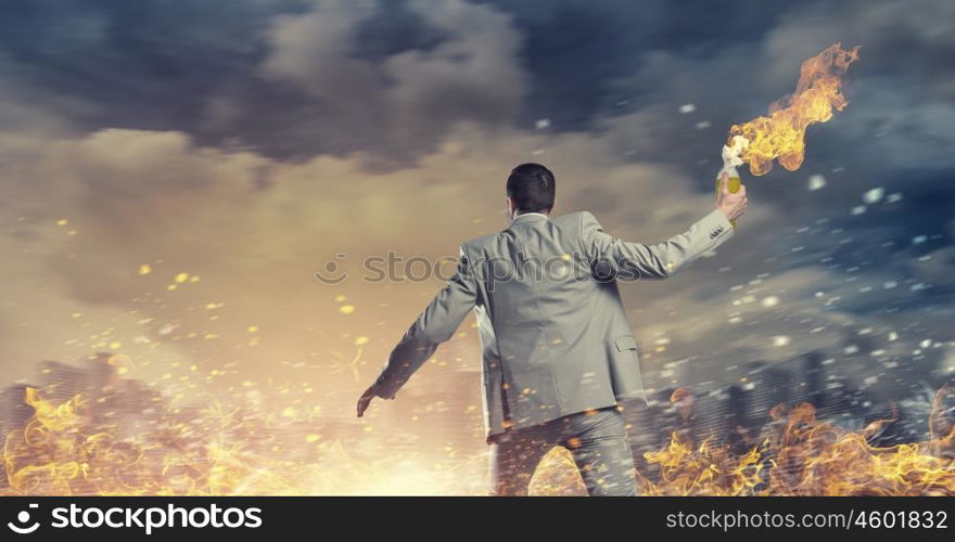 Businessman throwing petrol bomb. Aggressive businessman in suit throwing burning molotov cocktail