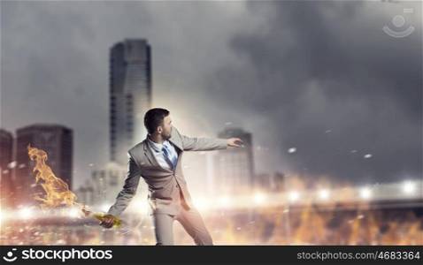 Businessman throwing petrol bomb. Aggressive businessman in suit throwing burning molotov cocktail