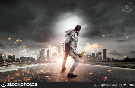 Businessman throwing petrol bomb. Aggressive businessman in suit throwing burning molotov cocktail