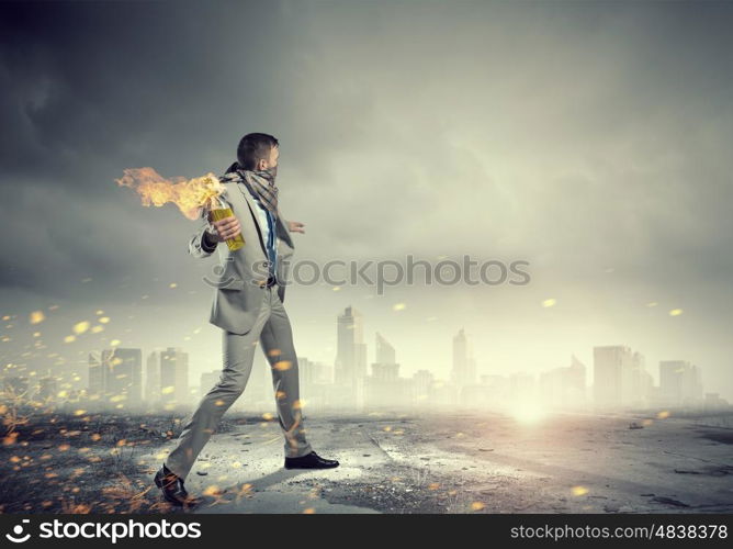 Businessman throwing petrol bomb. Aggressive businessman in suit throwing burning molotov cocktail