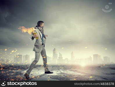 Businessman throwing petrol bomb. Aggressive businessman in suit throwing burning molotov cocktail