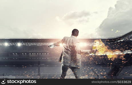 Businessman throwing petrol bomb. Aggressive businessman in suit throwing burning molotov cocktail