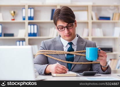 Businessman tied up with rope in office