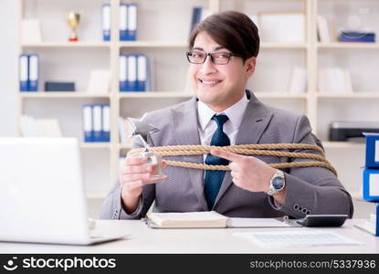 Businessman tied up with rope in office