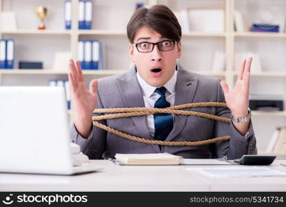 Businessman tied up with rope in office