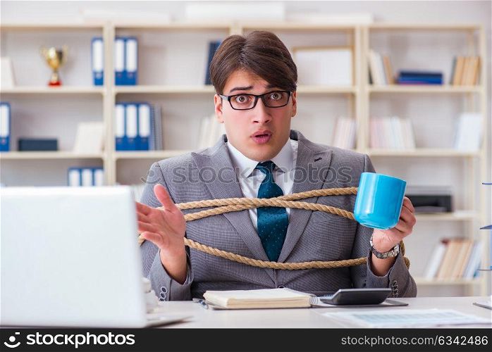 Businessman tied up with rope in office