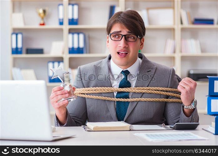 Businessman tied up with rope in office