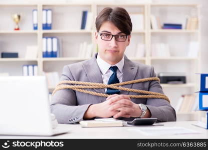 Businessman tied up with rope in office