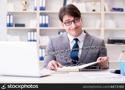 Businessman tied with chains to his work