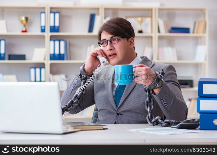 Businessman tied with chains to his work