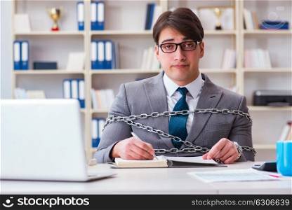 Businessman tied with chains to his work