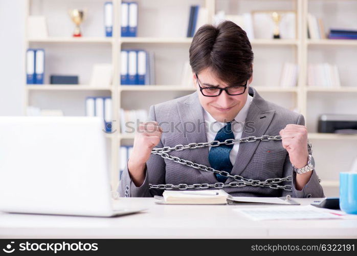 Businessman tied with chains to his work