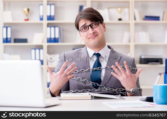 Businessman tied with chains to his work