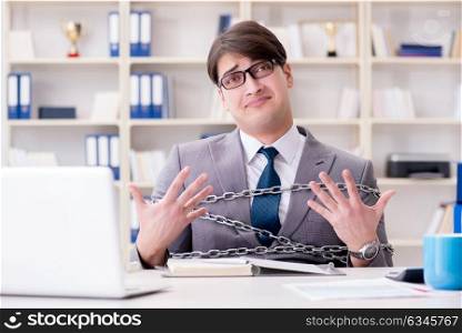 Businessman tied with chains to his work