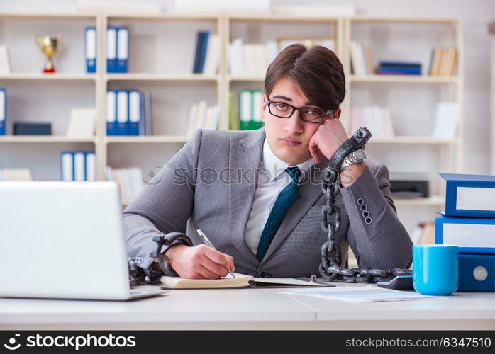 Businessman tied with chains to his work