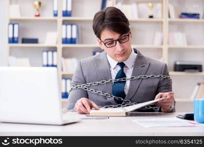 Businessman tied with chains to his work