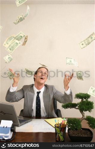 Businessman tossing dollar bills in the air