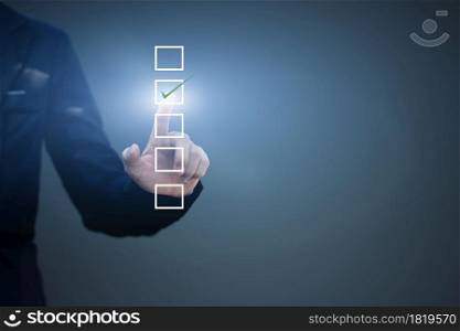Businessman touch checking mark in a checkbox on blue background. copy space