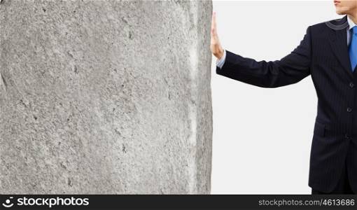Businessman touch wall. Businessman touching stone grey wall with palm