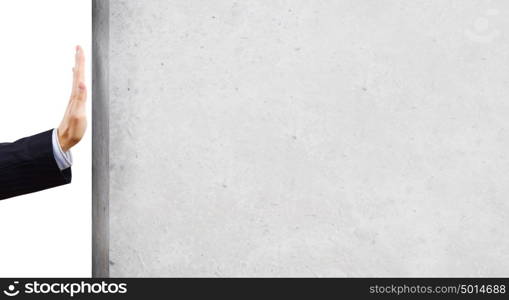 Businessman touch wall. Businessman touching stone grey wall with palm