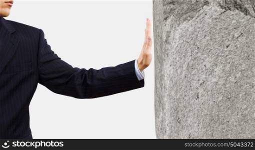 Businessman touch wall. Businessman touching stone grey wall with palm