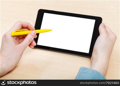 businessman touches by pen of tablet PC with cutout screen at office desk