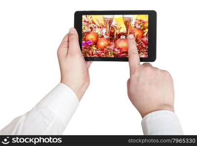 businessman touches tablet pc with Christmas still life on screen isolated on white background