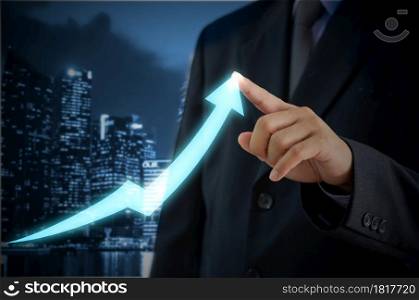 businessman touching an arrow on a virtual screen. Investment business and economic concept