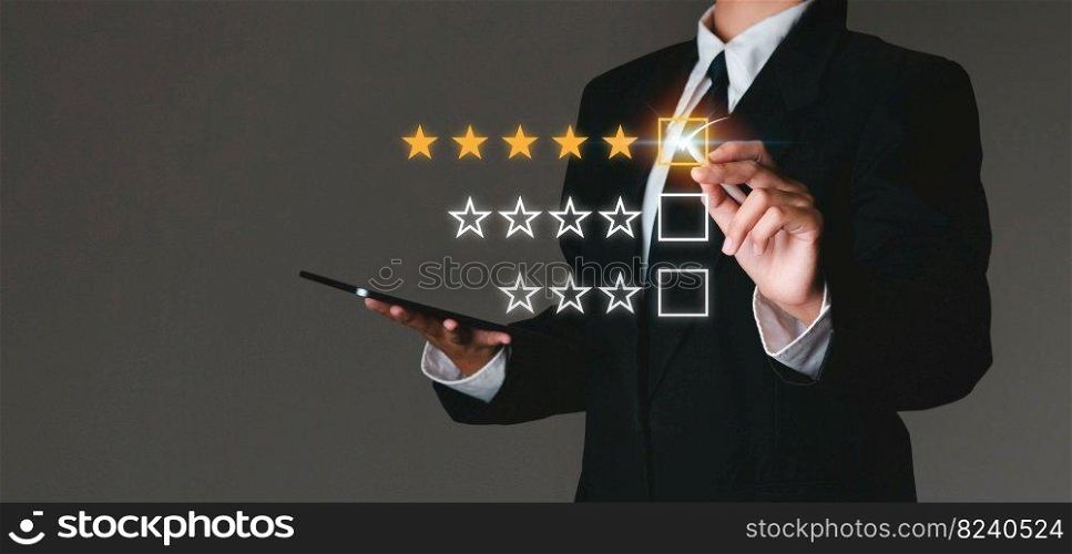 Businessman touching virtual screen on satisfaction rating icon in customer service and satisfaction concept. to give a good rating on the service That rating is a star icon.