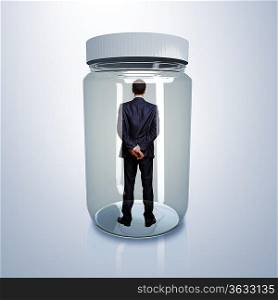 Businessman trapped inside a transparent glass jar