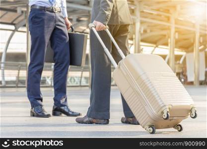 Businessman traveler with luggage at city background