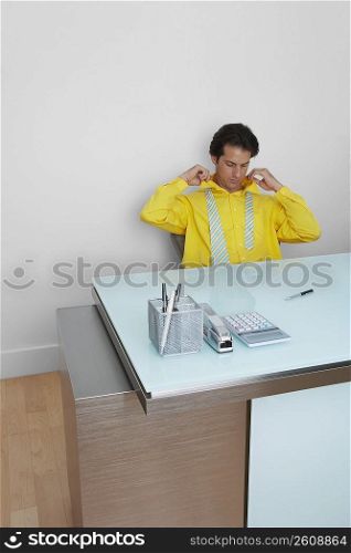 Businessman tying his tie in an office