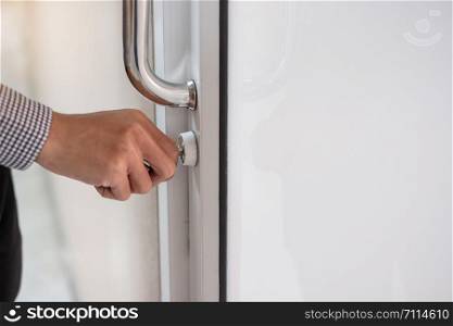 businessman tying key and unlocking doorknob to open the door in the office