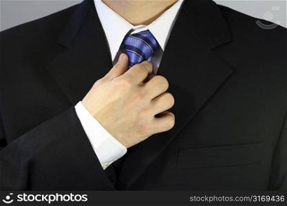 Businessman tying up his tie