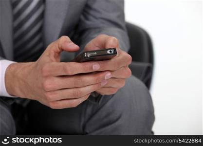 businessman typing on his cell phone