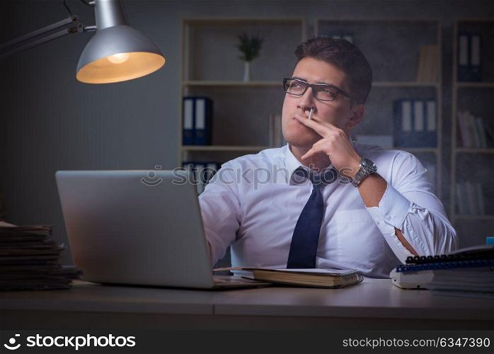 Businessman under stress smoking in office