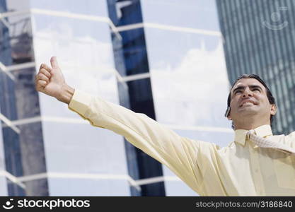 Businessman using a bluetooth device and making a thumbs up sign