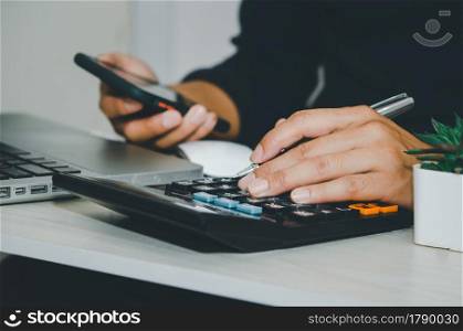 businessman using a calculator business tax financial or marketing business online.