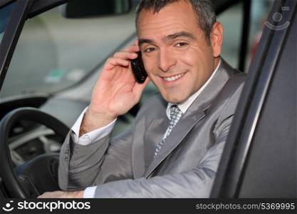 Businessman using a cellphone in his car