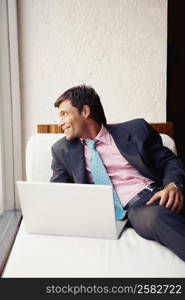 Businessman using a laptop and looking away