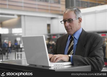 Businessman using a laptop at an airport